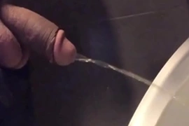 Dotado mijando sem a mão no mictório do banheiro público